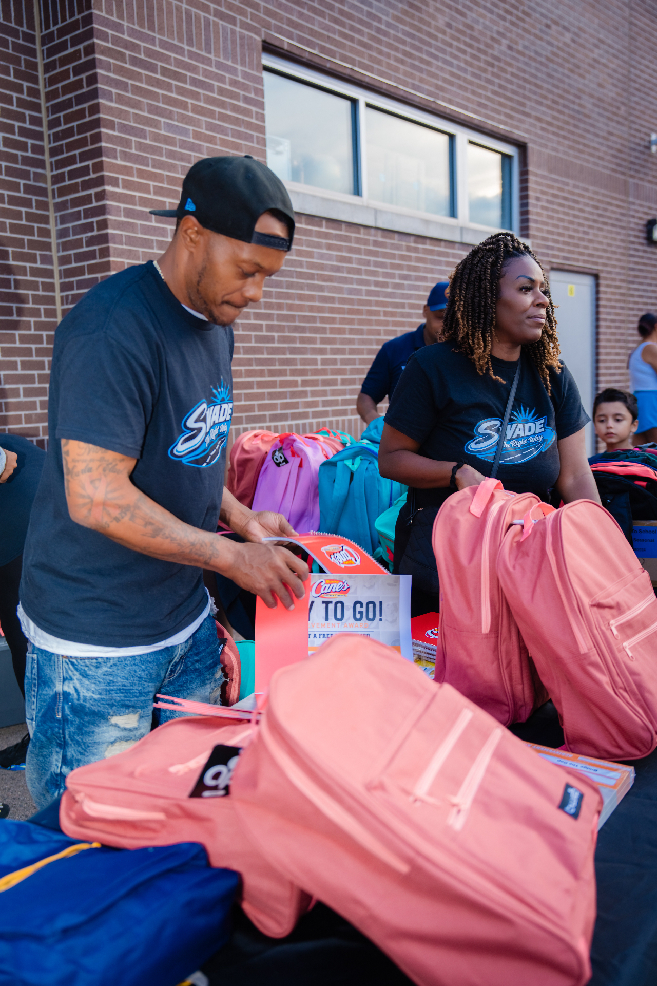 Volunteers preparing school supplies and backpacks