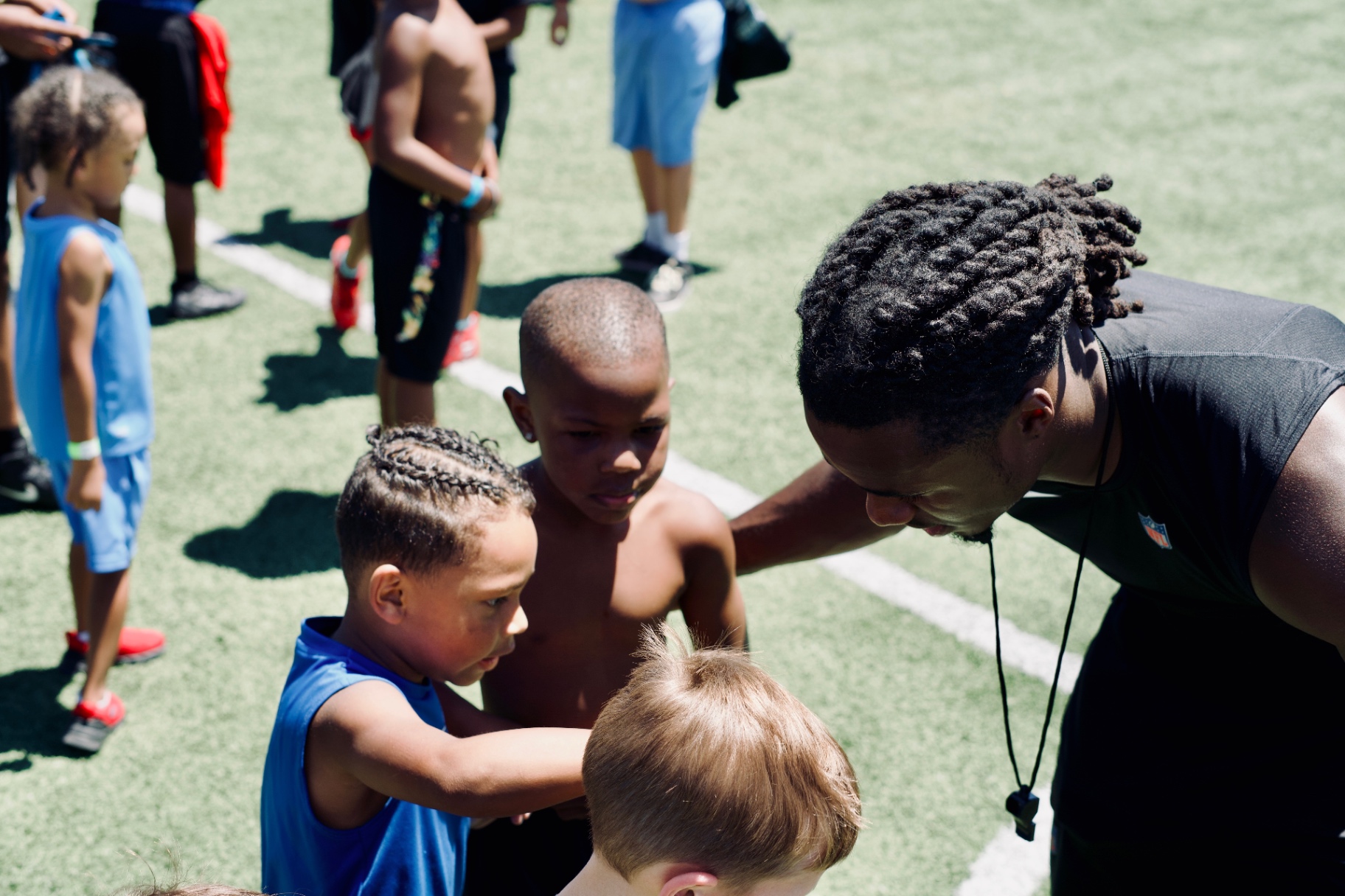 Chau kneeling to talk with young athletes