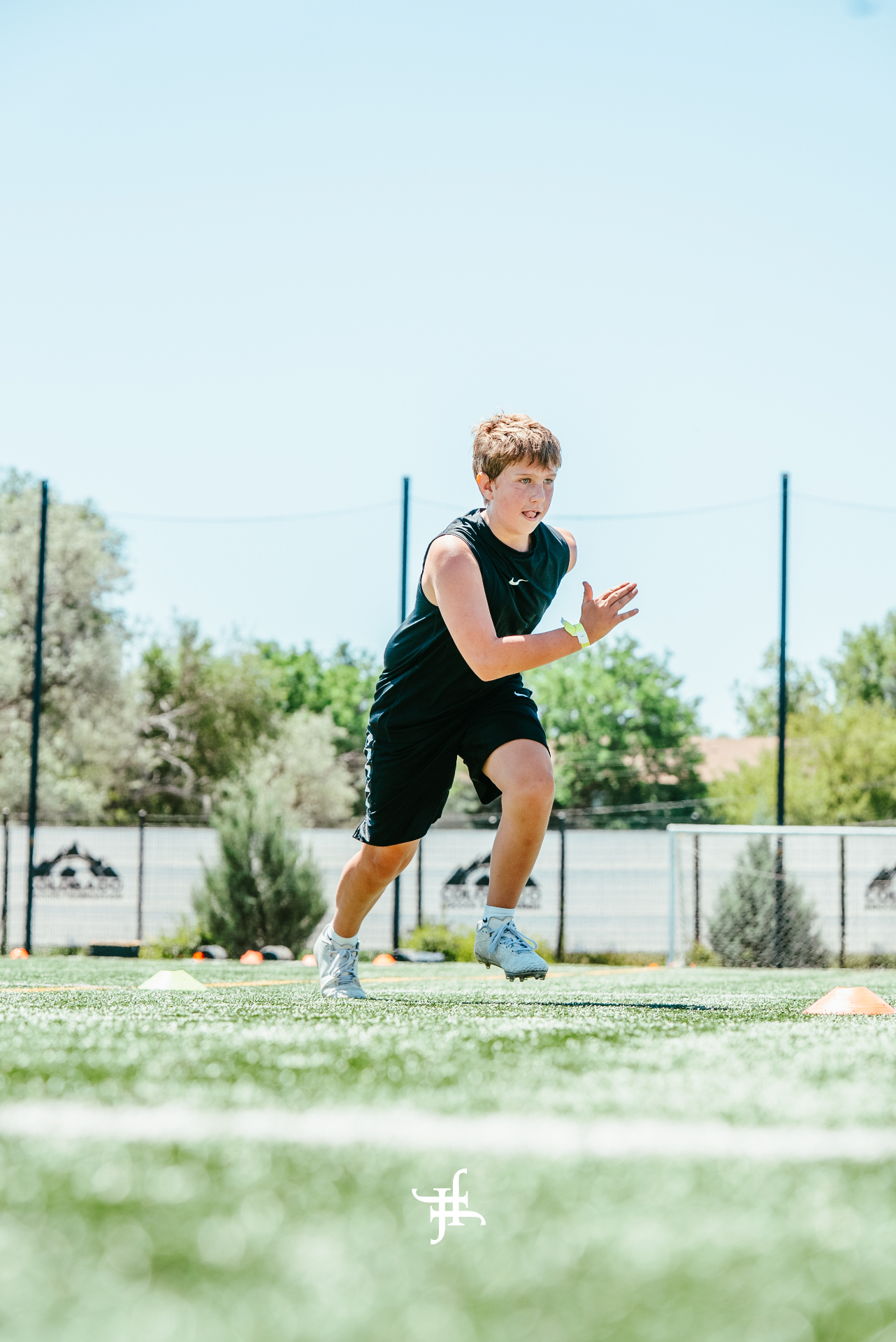Young athlete sprinting through cones