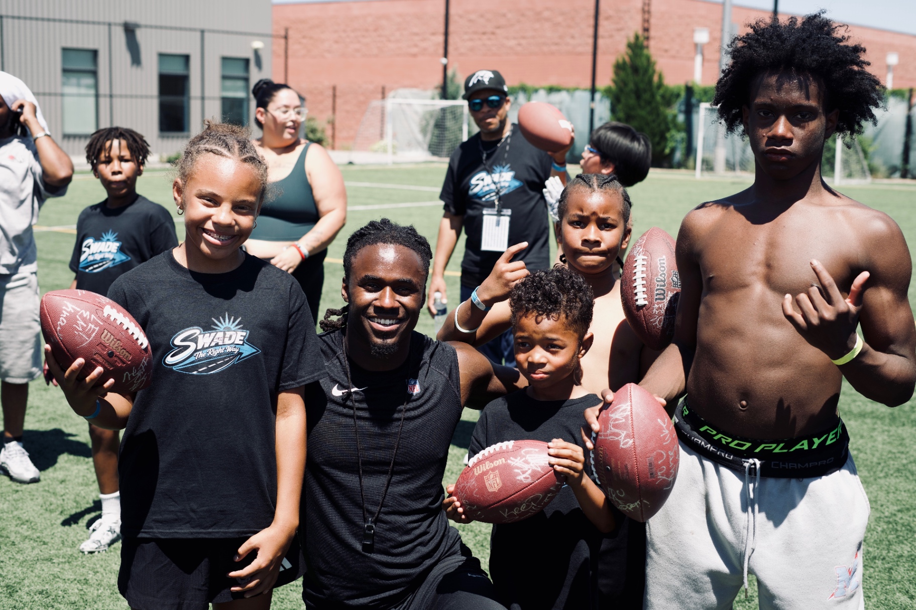 Chau Smith-Wade with young campers holding footballs