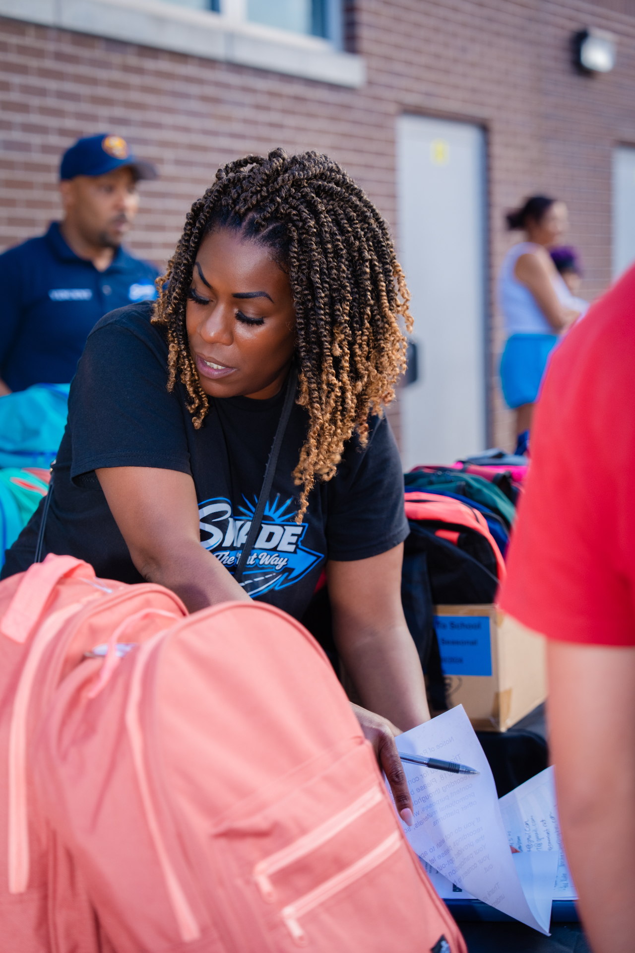 Volunteer sorting backpacks at the Back to School drive