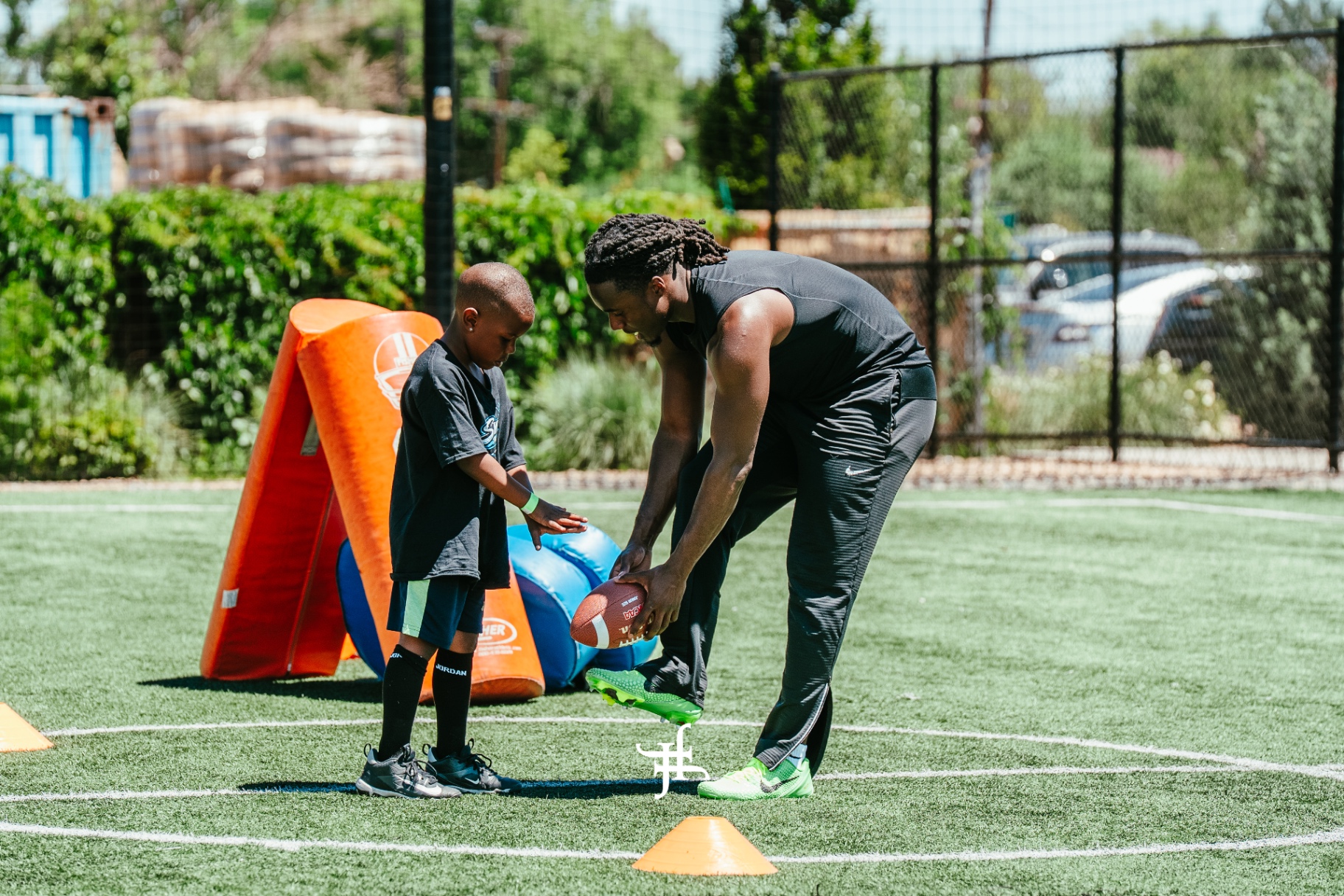 Coach working one on one with a young camper on the field